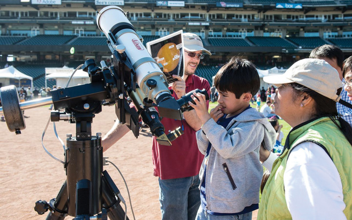 A curious young future scientist explores astronomy and telescopes at the Bay Area Science Festival. Credit: John van Eyck.