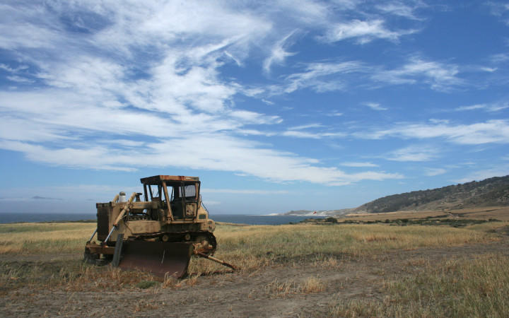 An abandoned tractor on Santa Rosa Island, indicative of 20th-century human exploitation of the Channel Islands. Santa Cruz Island can be seen in the distance on the left. (Levi Gadye)